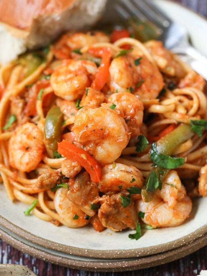 Cajun jambalaya pasta on a gray plate with a silver fork.