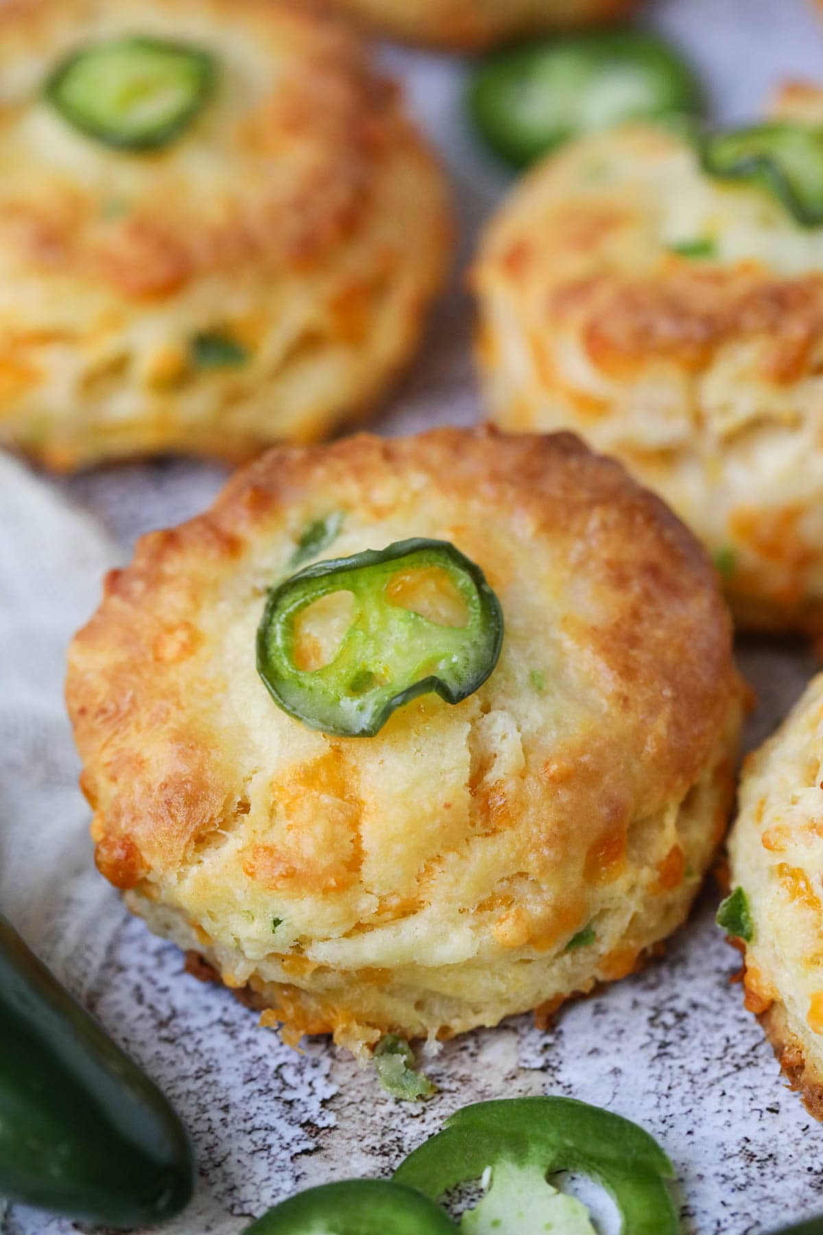 Cheddar jalapeno biscuits arranged on a white surface.