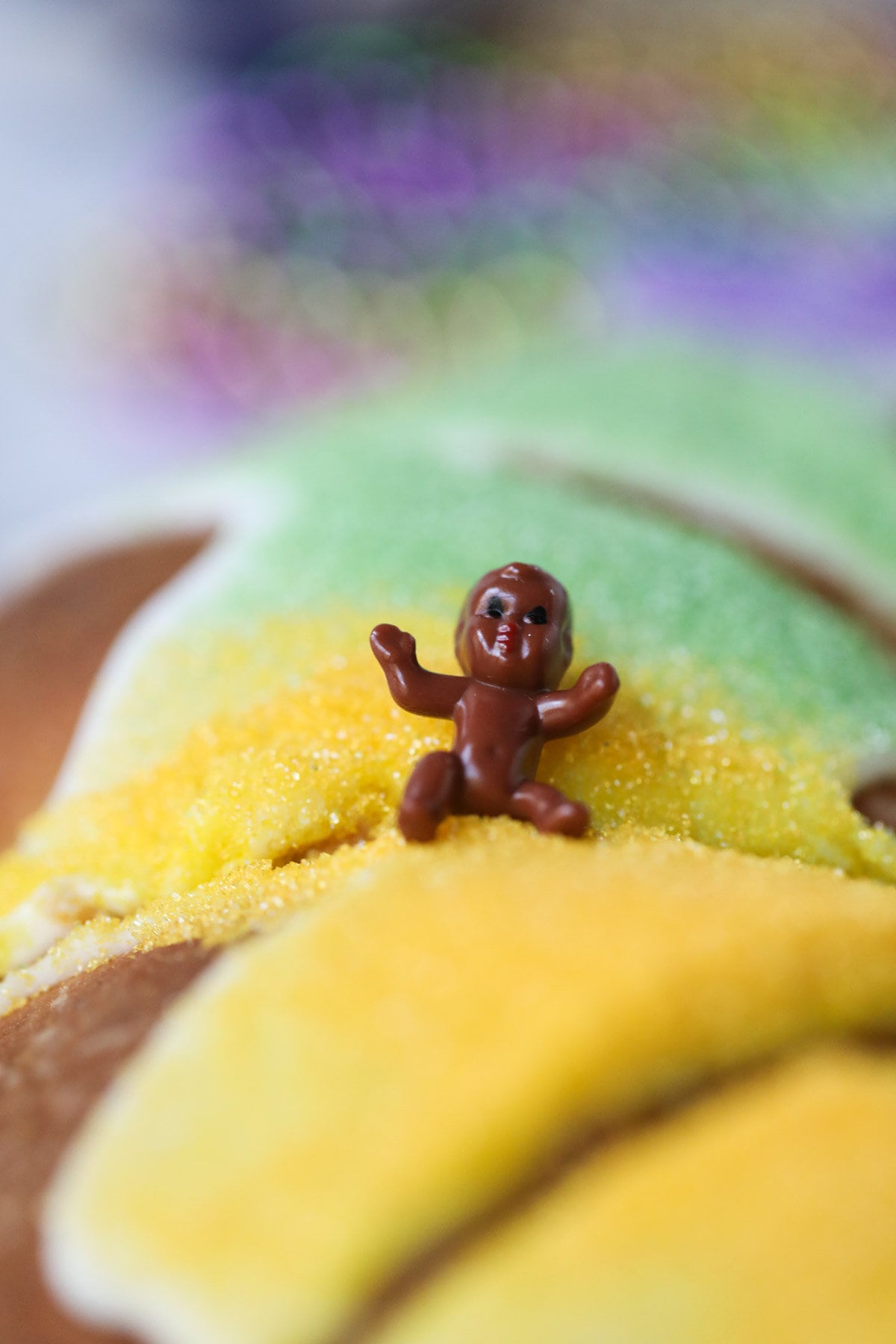 Plastic baby sitting on top of a king cake.