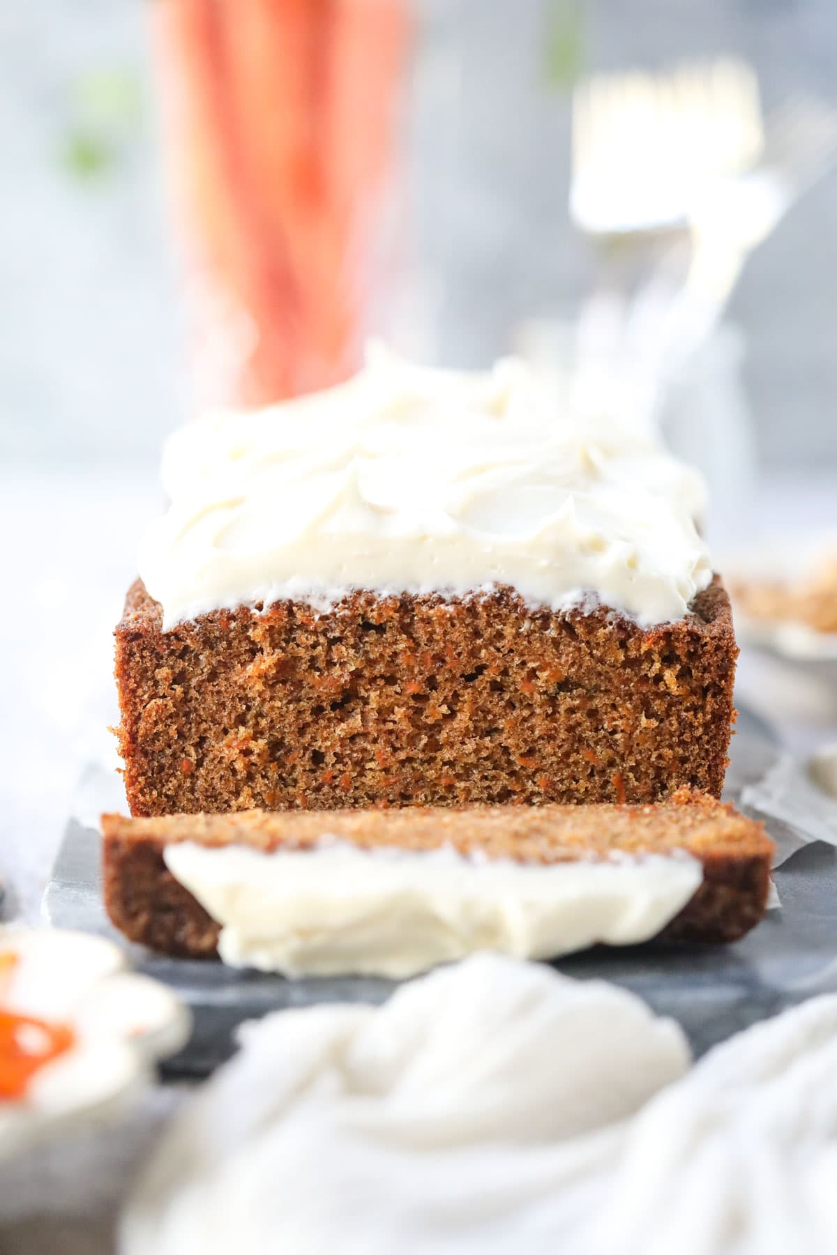 Sliced carrot cake loaf on a white surface.