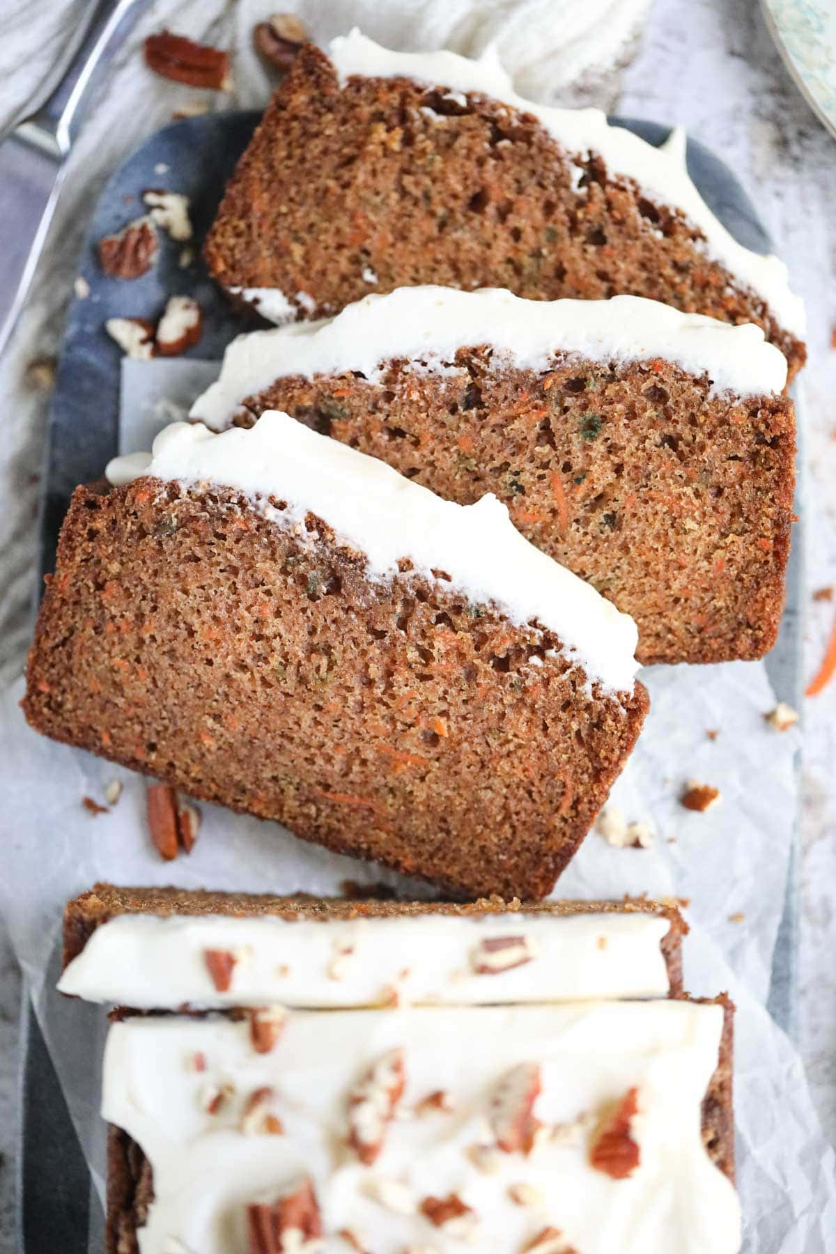 Sliced carrot cake on a marble cutting board.