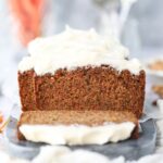 Sliced carrot cake loaf on a marble cutting board.
