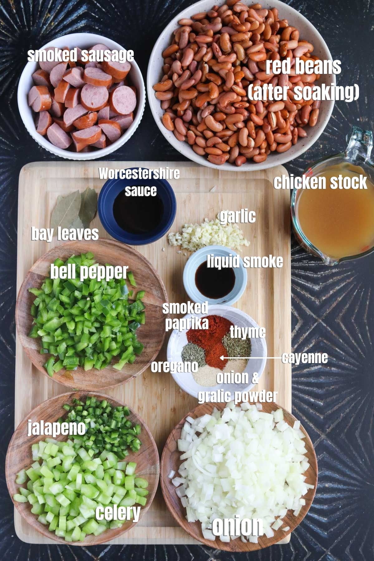 Ingredients for making Louisiana red beans and rice spread out on a black surface.