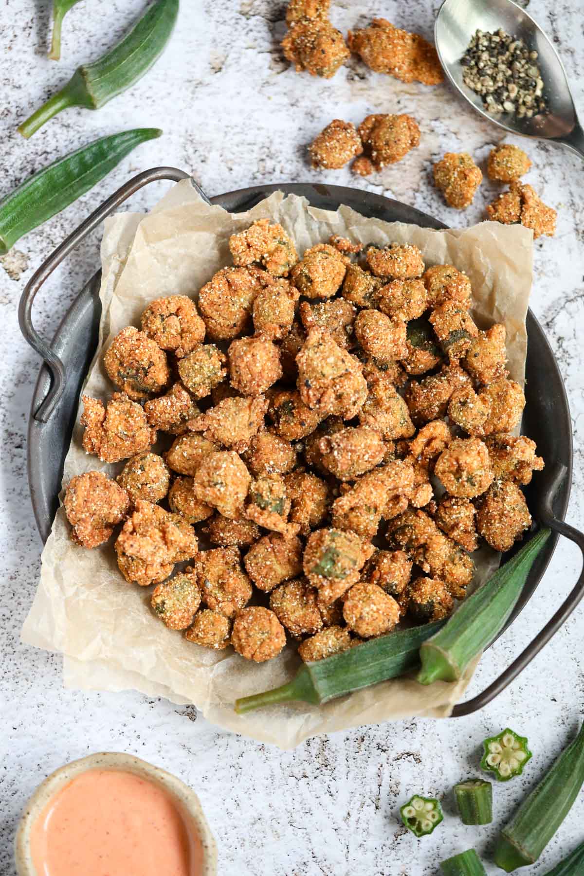 Southern fried okra on a metal tray sitting on a white surface.