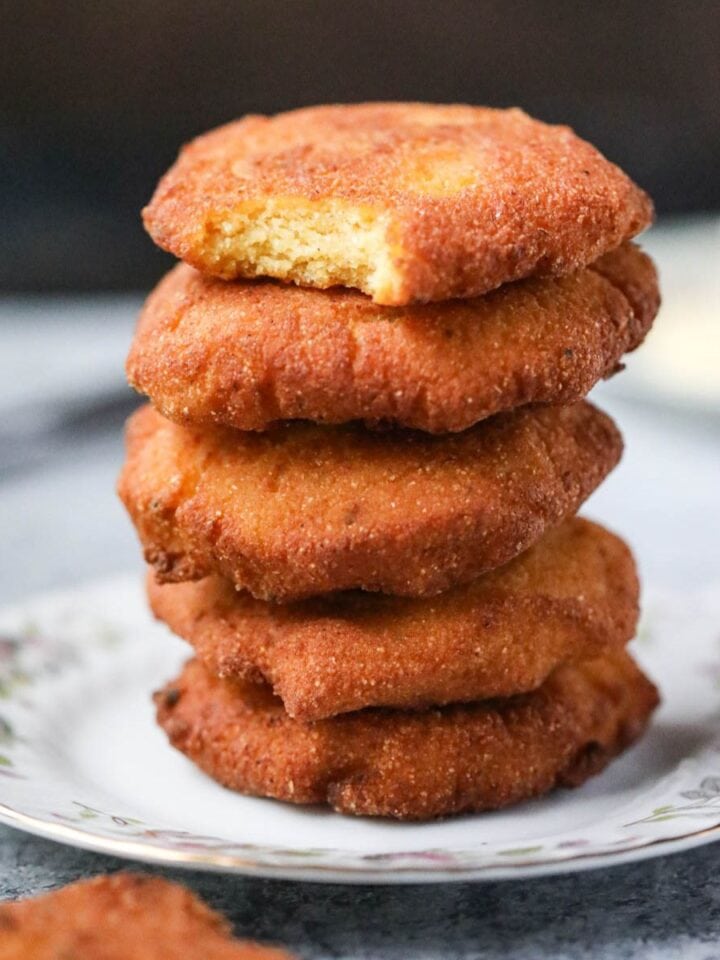 Hot water cornbread stacked on a white plate.