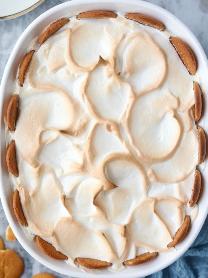 Old-fashioned banana pudding in a white baking dish sitting on top of a gray surface.