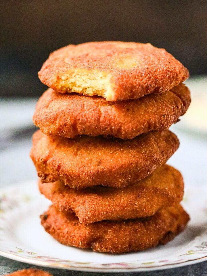 A stack of hot water cornbread patties on a plate.