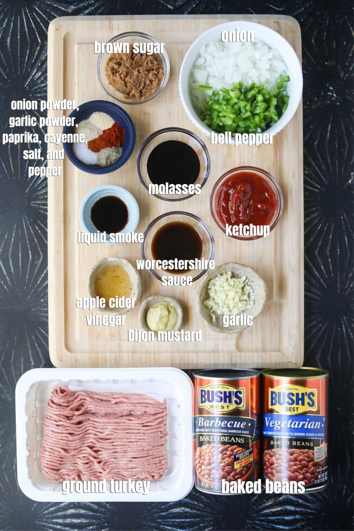 Ingredients for making southern baked beans spread out on a black surface.