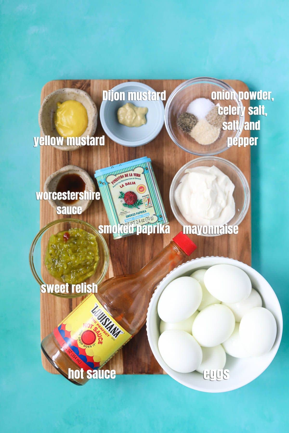 Ingredients for making southern deviled eggs arranged on a wooden cutting board.