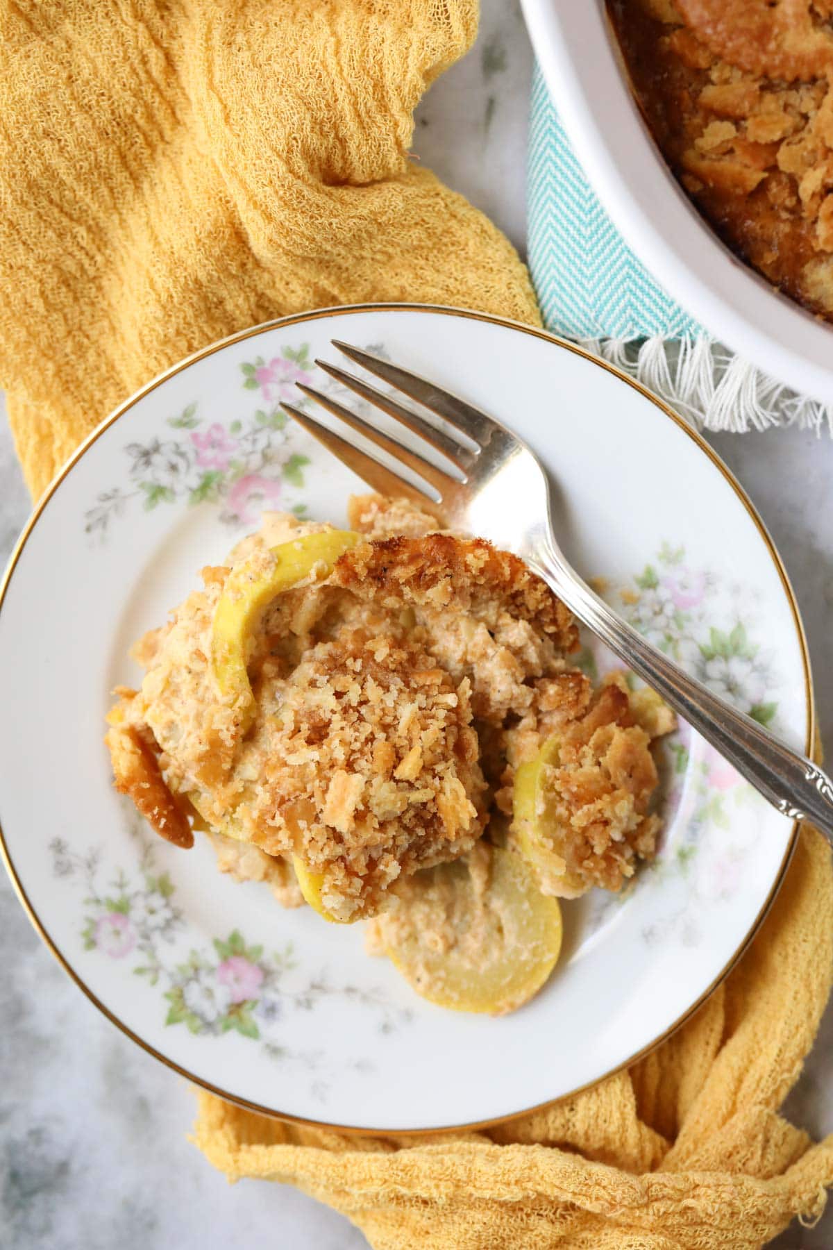 Southern squash casserole on a white plate with a silver fork.