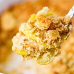 Photo of a serving of southern squash casserole on a serving spoon.