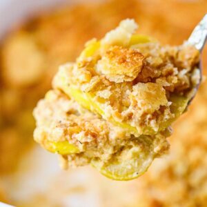 Photo of a serving of southern squash casserole on a serving spoon.