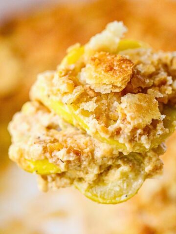 Photo of a serving of southern squash casserole on a serving spoon.