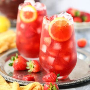 Strawberry sweet iced tea in tall glasses on a metal serving tray.