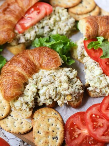 Southern chicken salad sandwiches arranged on a wooden cutting board.