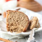 A slice of apple cider donut cake on a white plate.