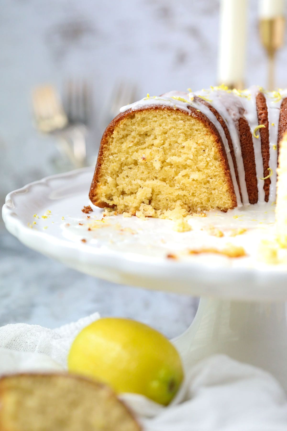 Moist lemon Bundt cake on a white cake plate.