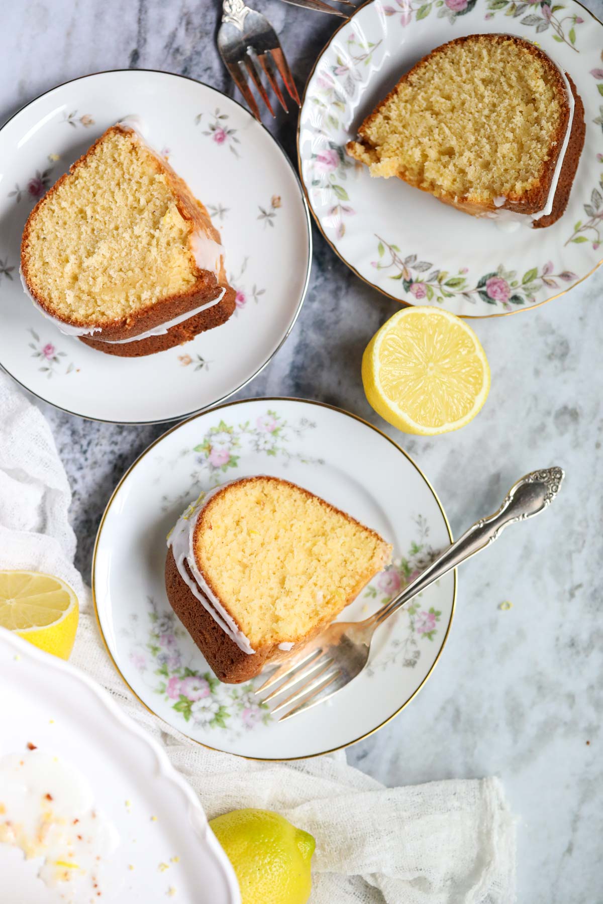 Slices of moist lemon Bundt cake on white plates.