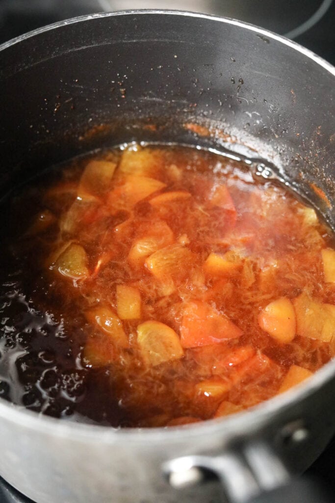 Peach simple syrup after simmering in a medium saucepan.