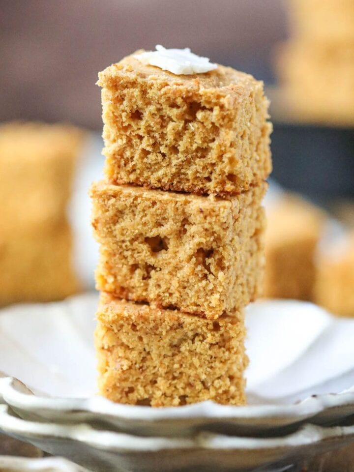 Sweet potato cornbread slices stacked on a white plate.