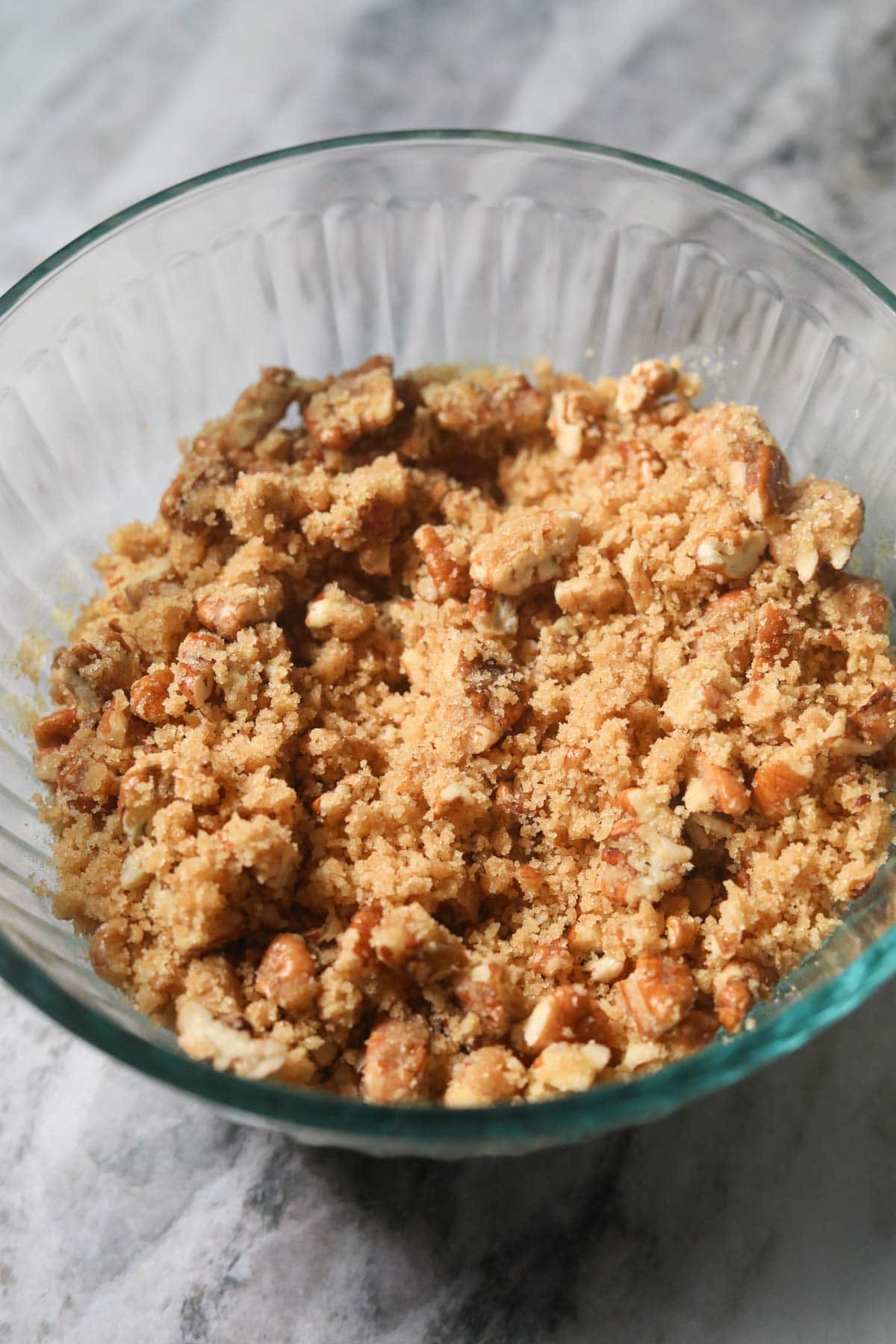 Pecan crumble topping for sweet potato casserole in a small mixing bowl.