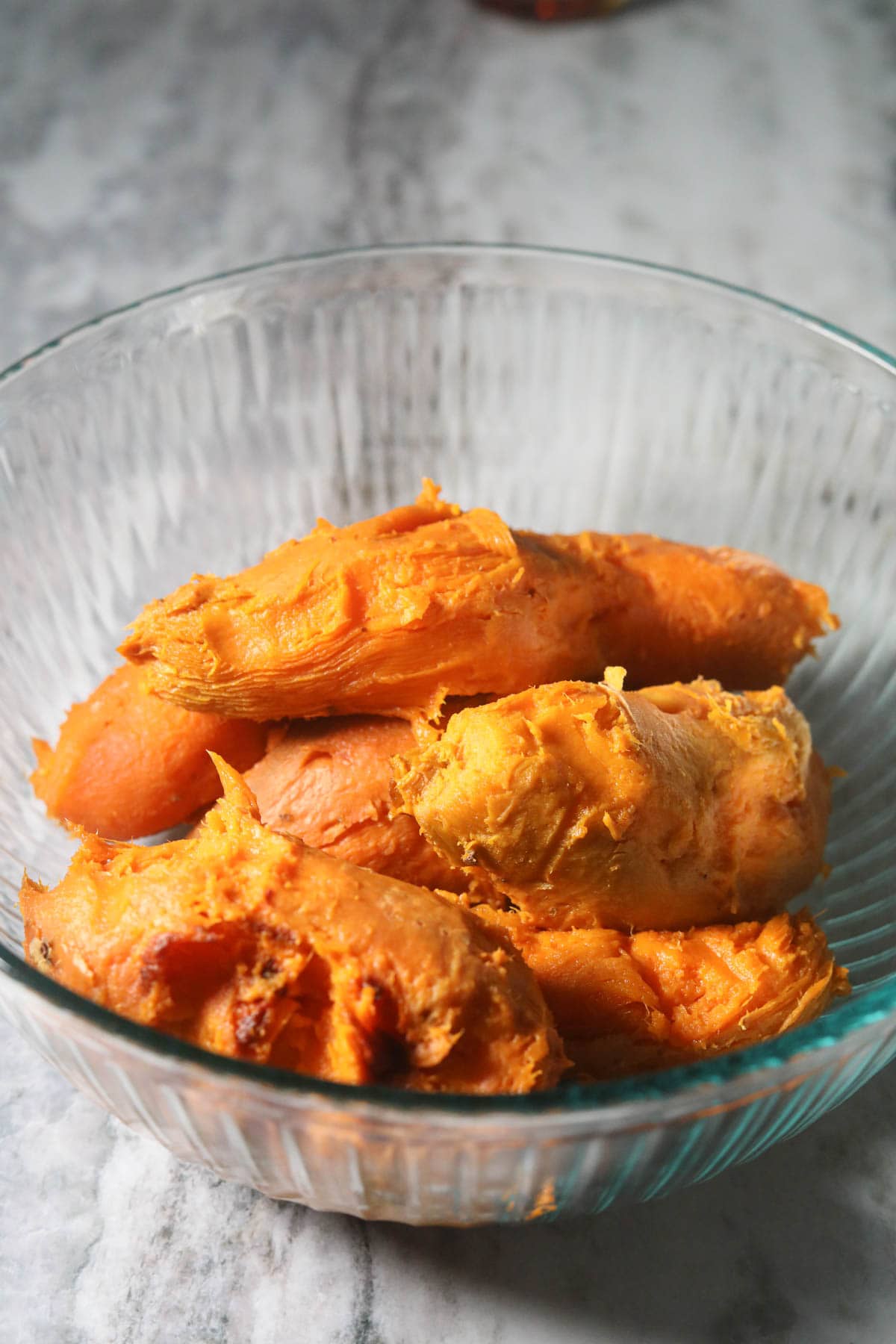 Roasted and peeled sweet potatoes in a mixing bowl.