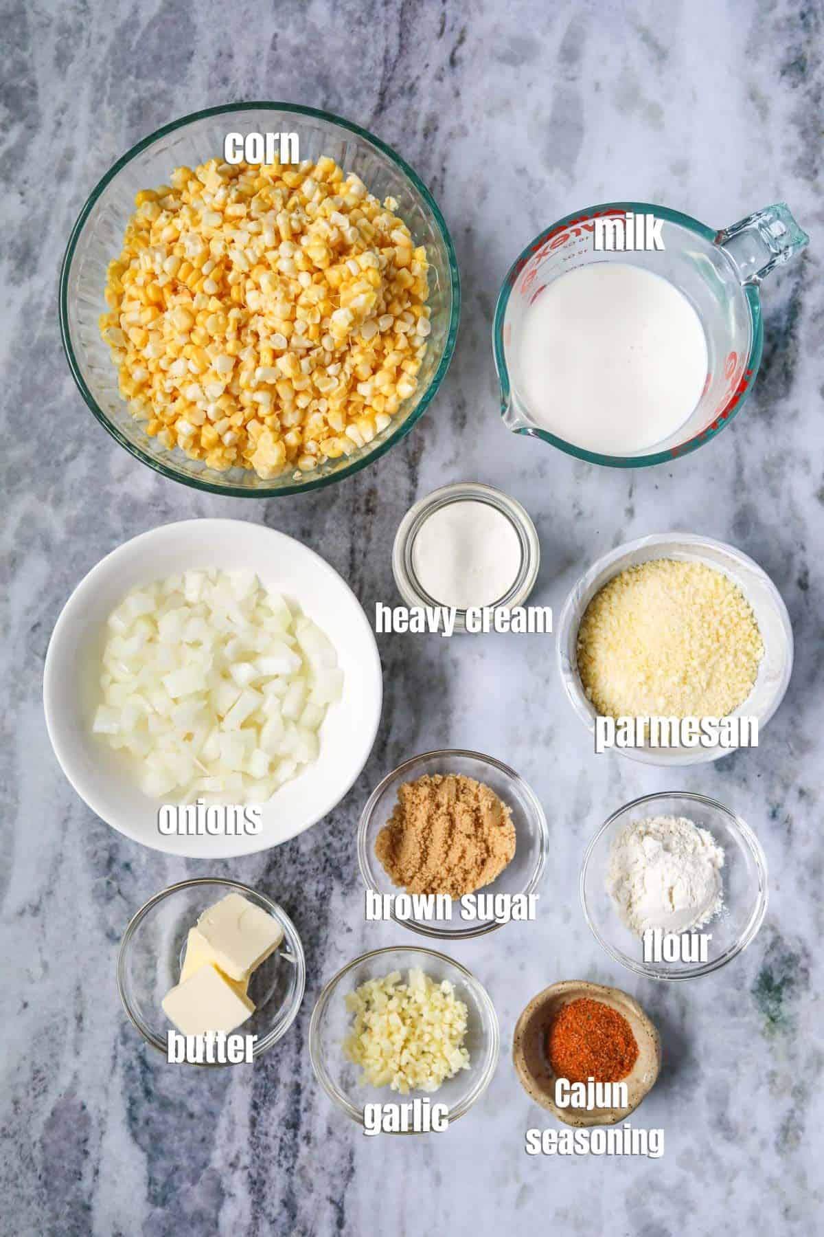 Ingredients for making homemade creamed corn arranged on a gray marble surface.