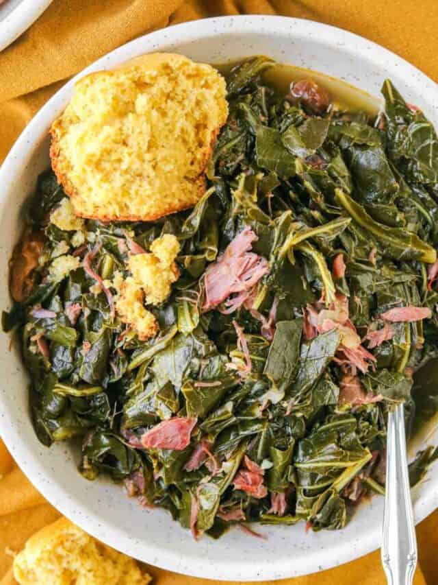 Southern collard greens in a white bowl with a piece of cornbread.