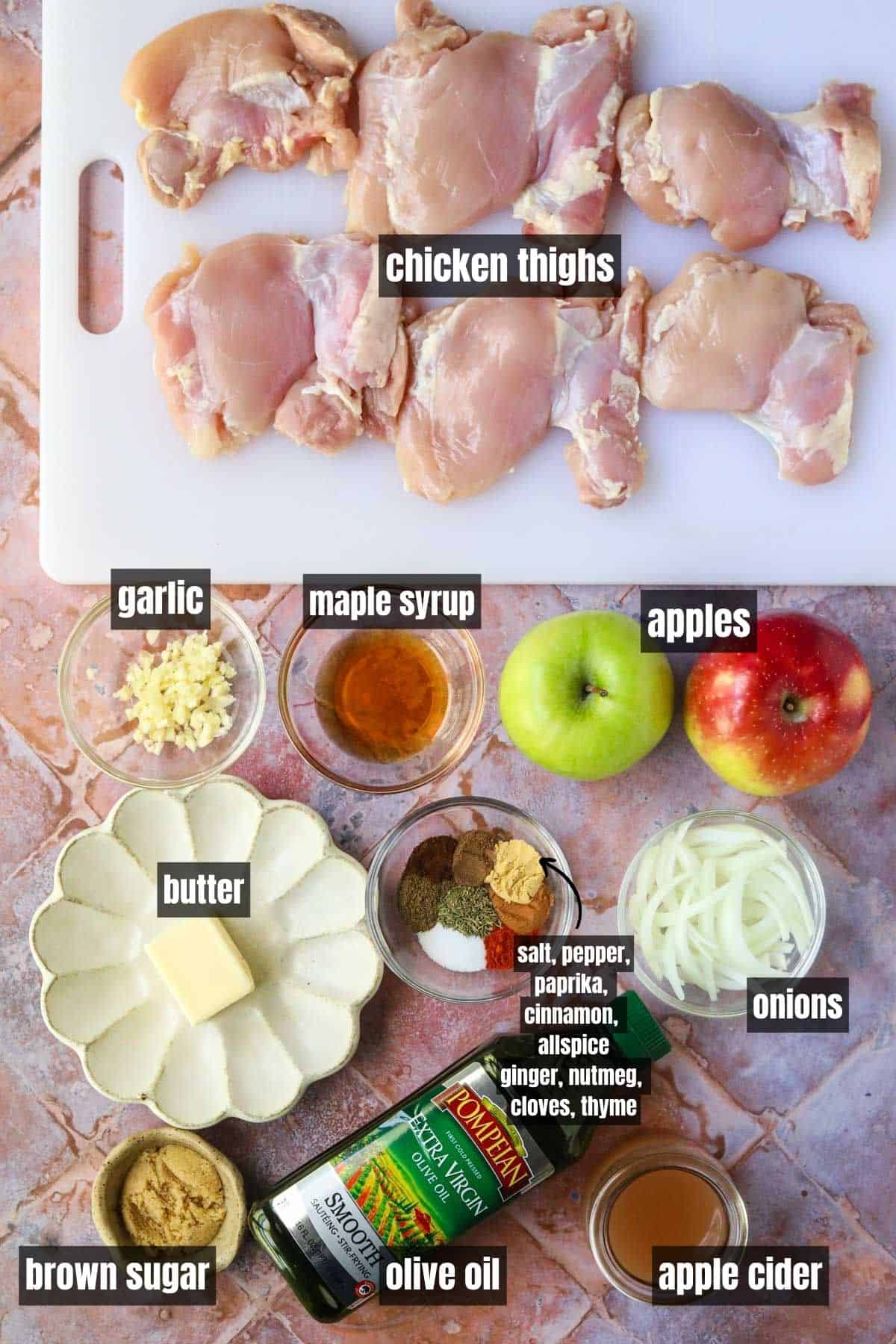 ingredients for making apple cider chicken arranged on a tile surface.