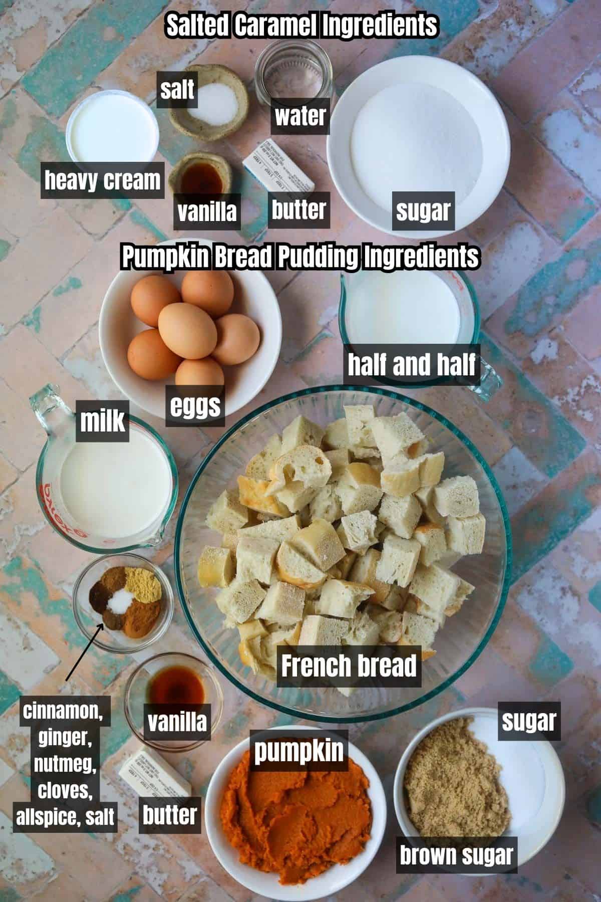 Ingredients for making pumpkin bread pudding with salted caramel sauce arranged on a tile surface.