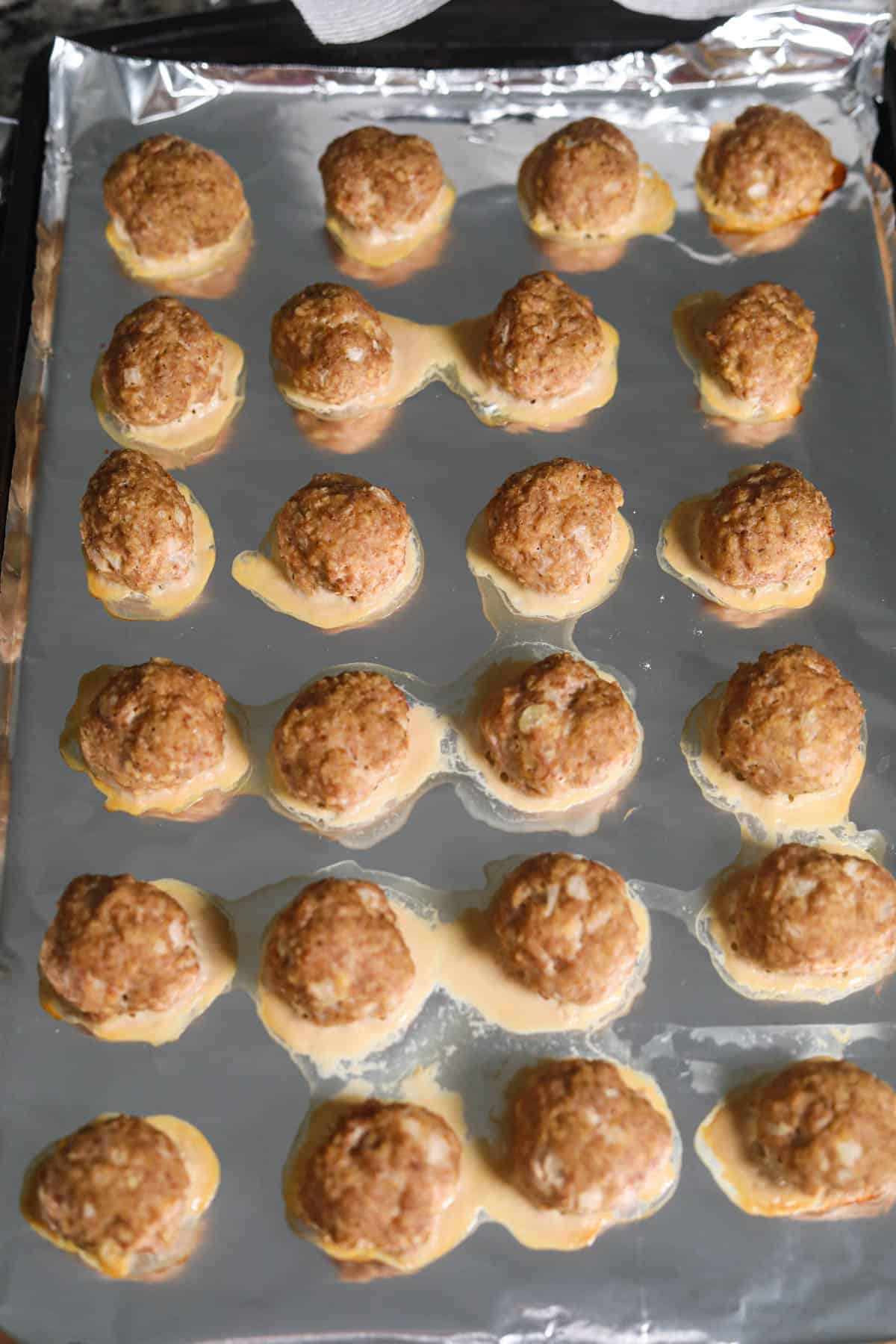 Cranberry meatballs on a baking sheet.