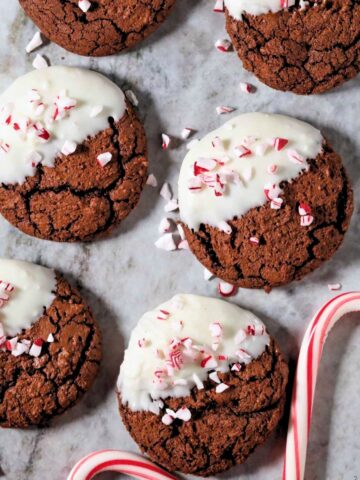 Peppermint bark brownie cookies arranged on a marble surface.