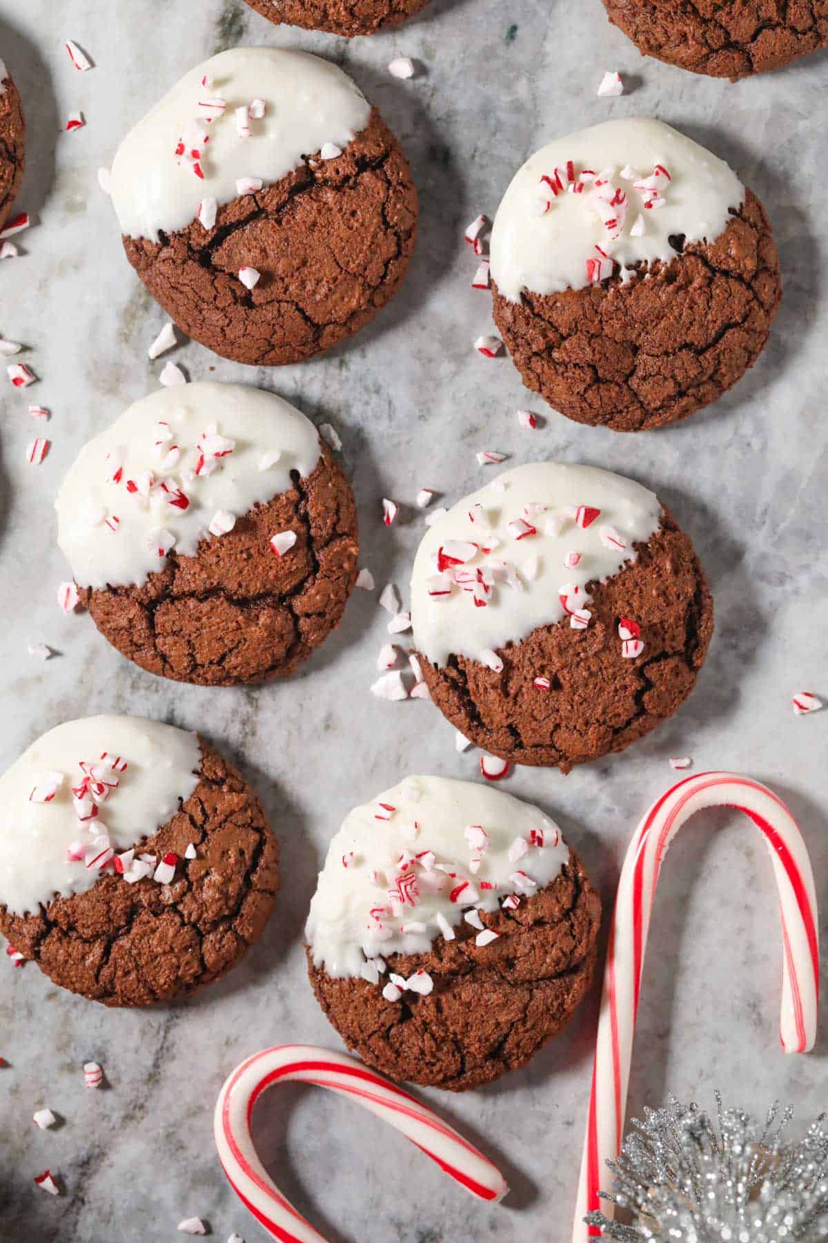 Peppermint bark brownie cookies arranged on a marble surface.