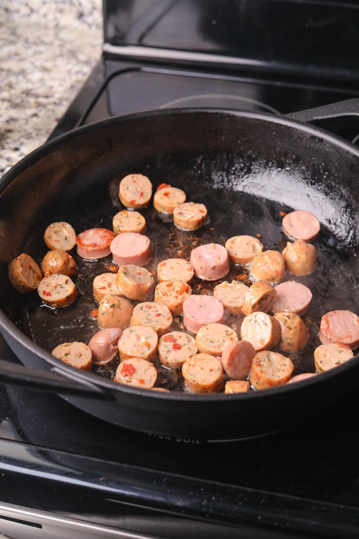 Sausage cooking in a skillet.