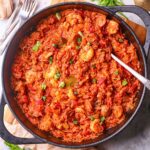 A pan of shrimp and sausage jambalaya, packed with vibrant colors, bold Cajun spices, and hearty ingredients on a tabletop.