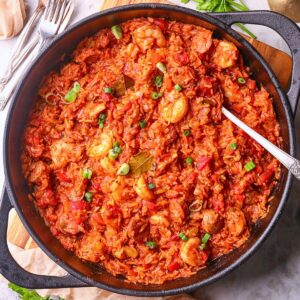 A pan of shrimp and sausage jambalaya, packed with vibrant colors, bold Cajun spices, and hearty ingredients on a tabletop.