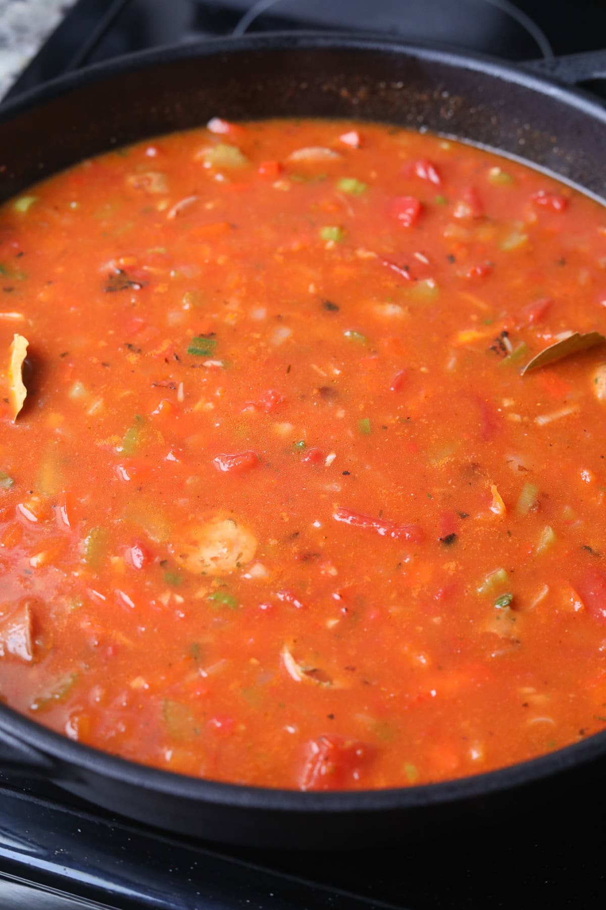Shrimp and sausage jambalaya with rice simmering on the stove top.