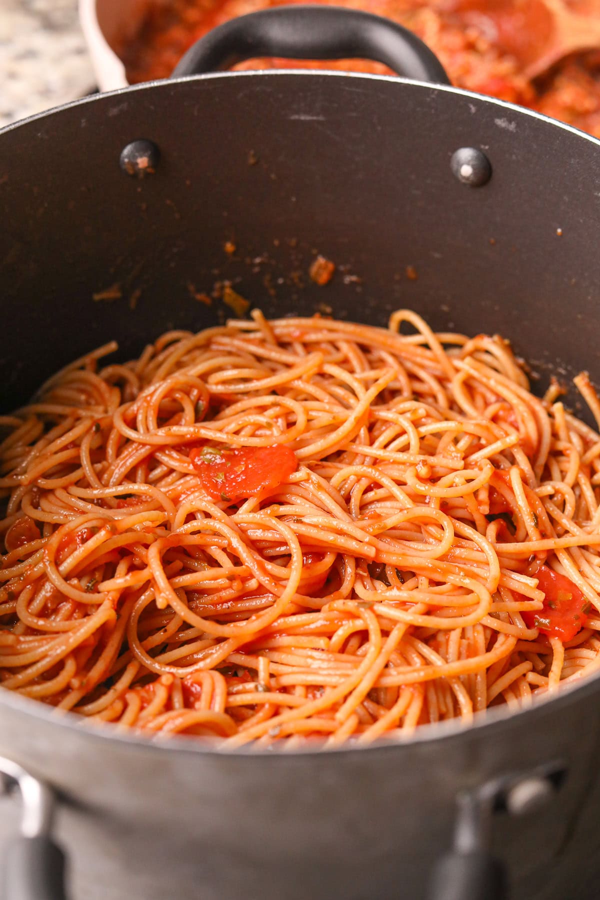 Spaghetti with pasta sauce in a pan.