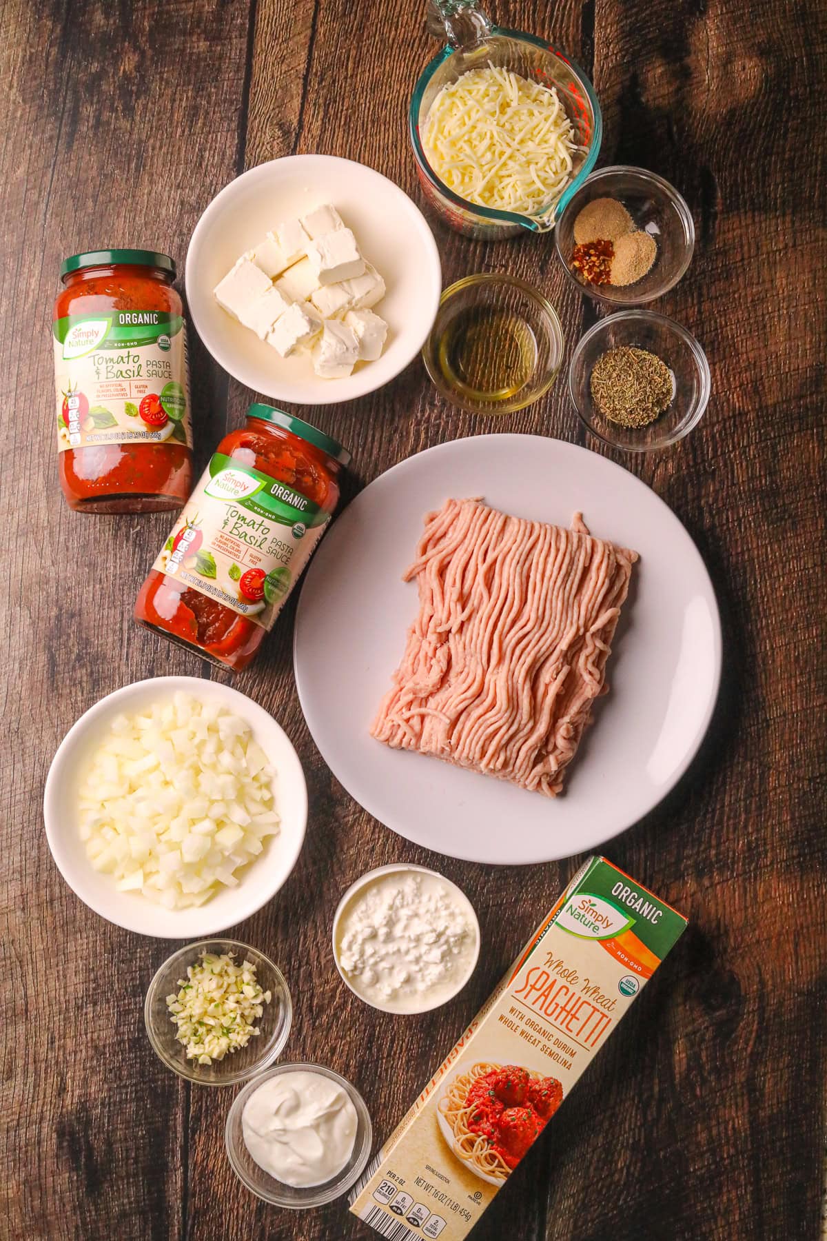 Ingredients for making million dollar spaghetti arranged on a wooden table top.