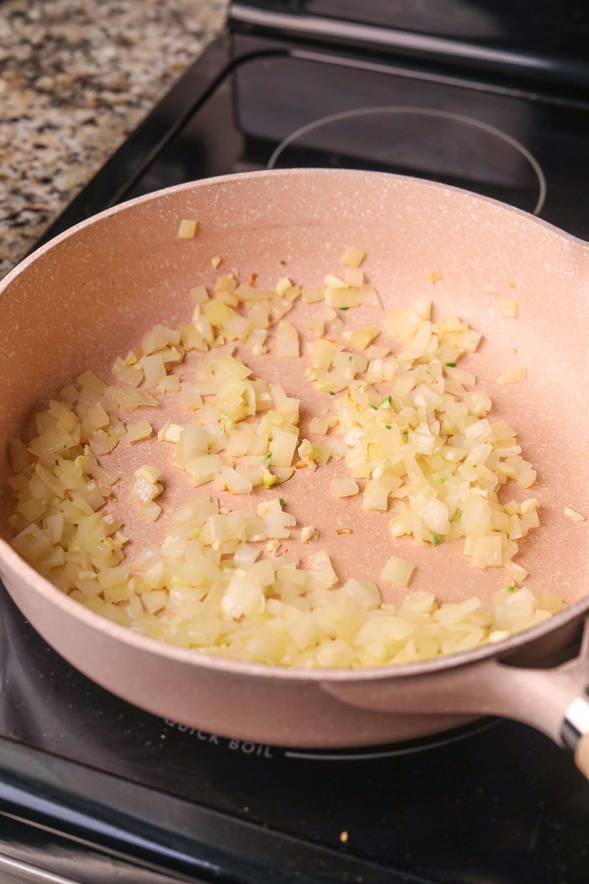 Onion sautéing in a skillet.
