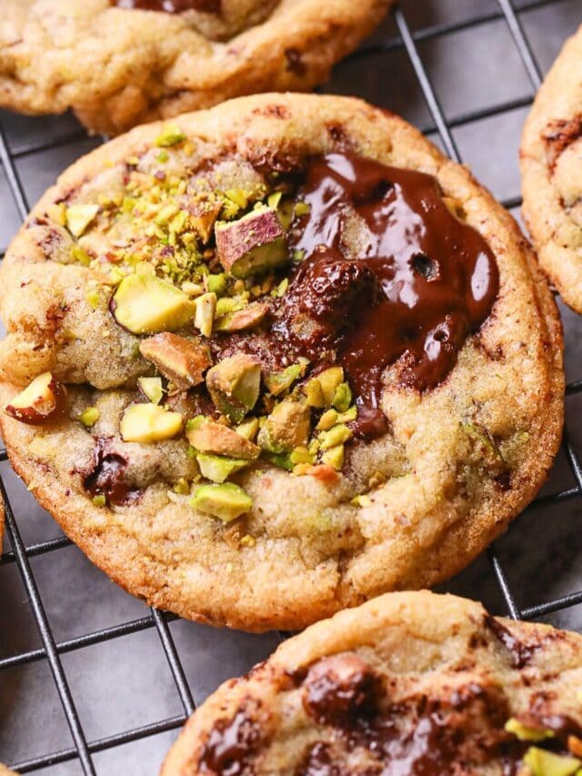 Brown butter pistachio chocolate chip cookies on a baking sheet.