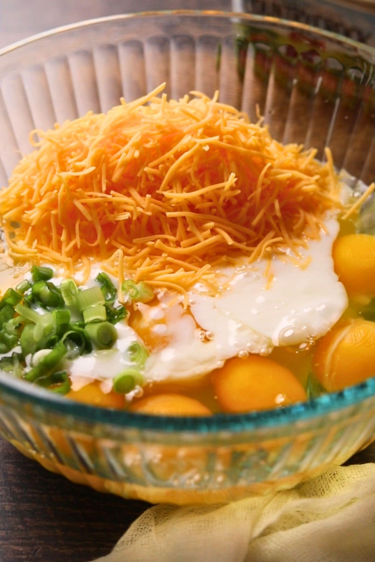 Egg mixture in a mixing bowl for making buttermilk biscuit breakfast casserole.