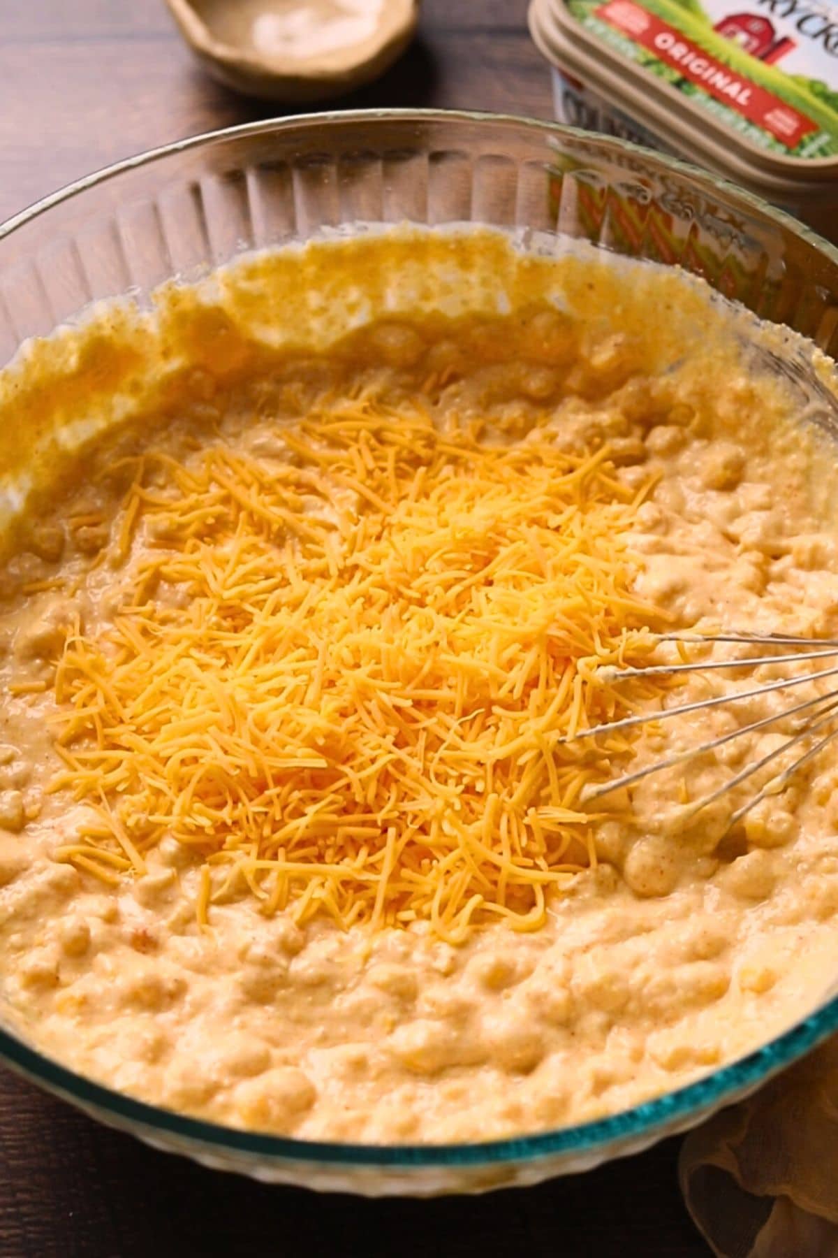 Creamy cheesy cornbread casserole batter in a mixing bowl.