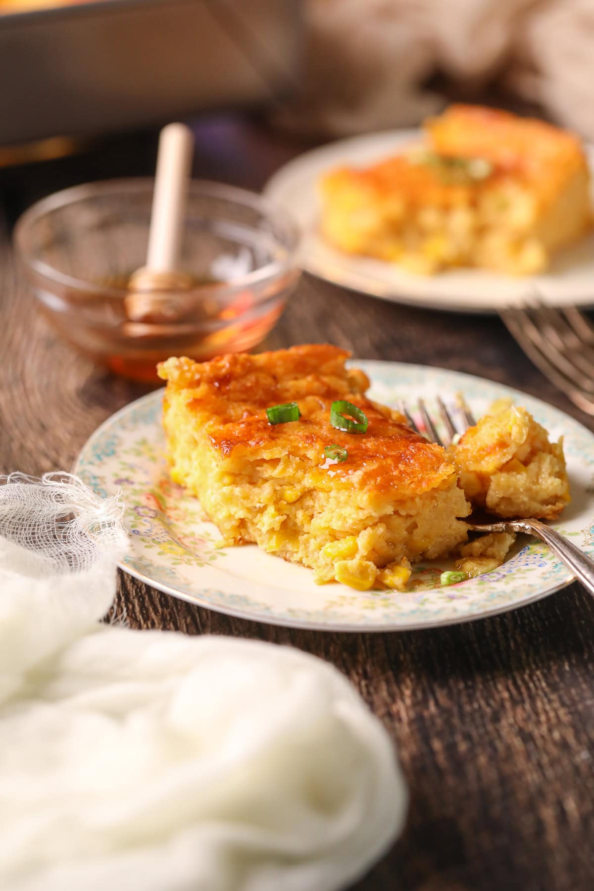 Photo of creamy cheesy corn casserole baked with cheddar and chives.