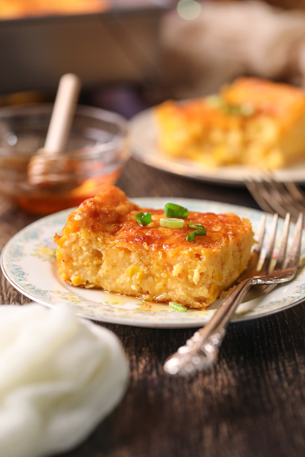 Photo of creamy cheesy corn casserole baked with cheddar and chives.