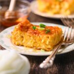 Photo of creamy cheesy corn casserole baked with cheddar and chives.