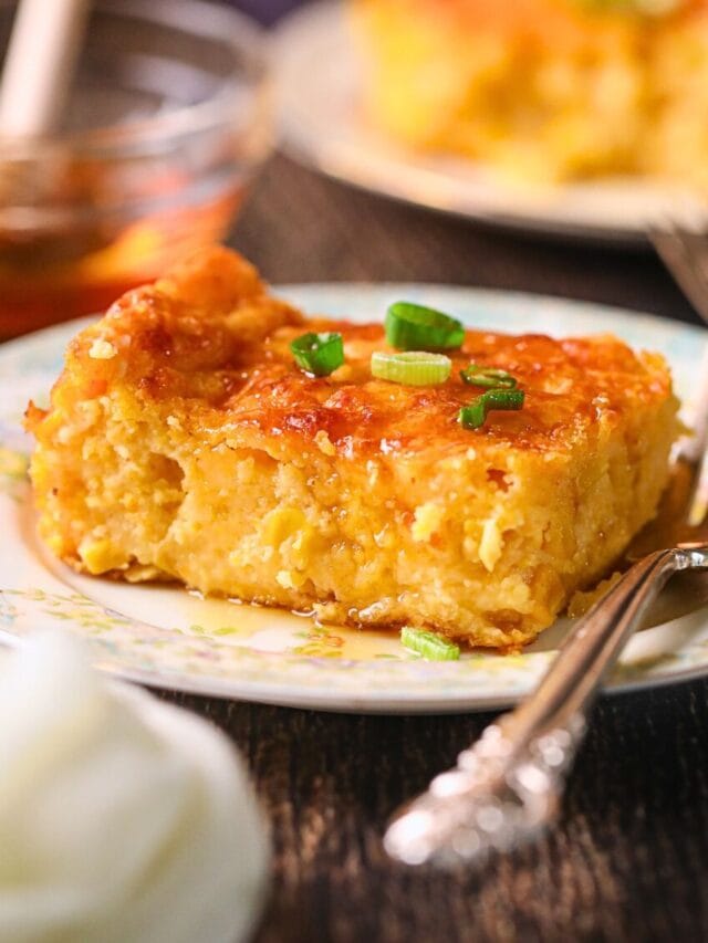 Photo of creamy cheesy corn casserole baked with cheddar and chives.