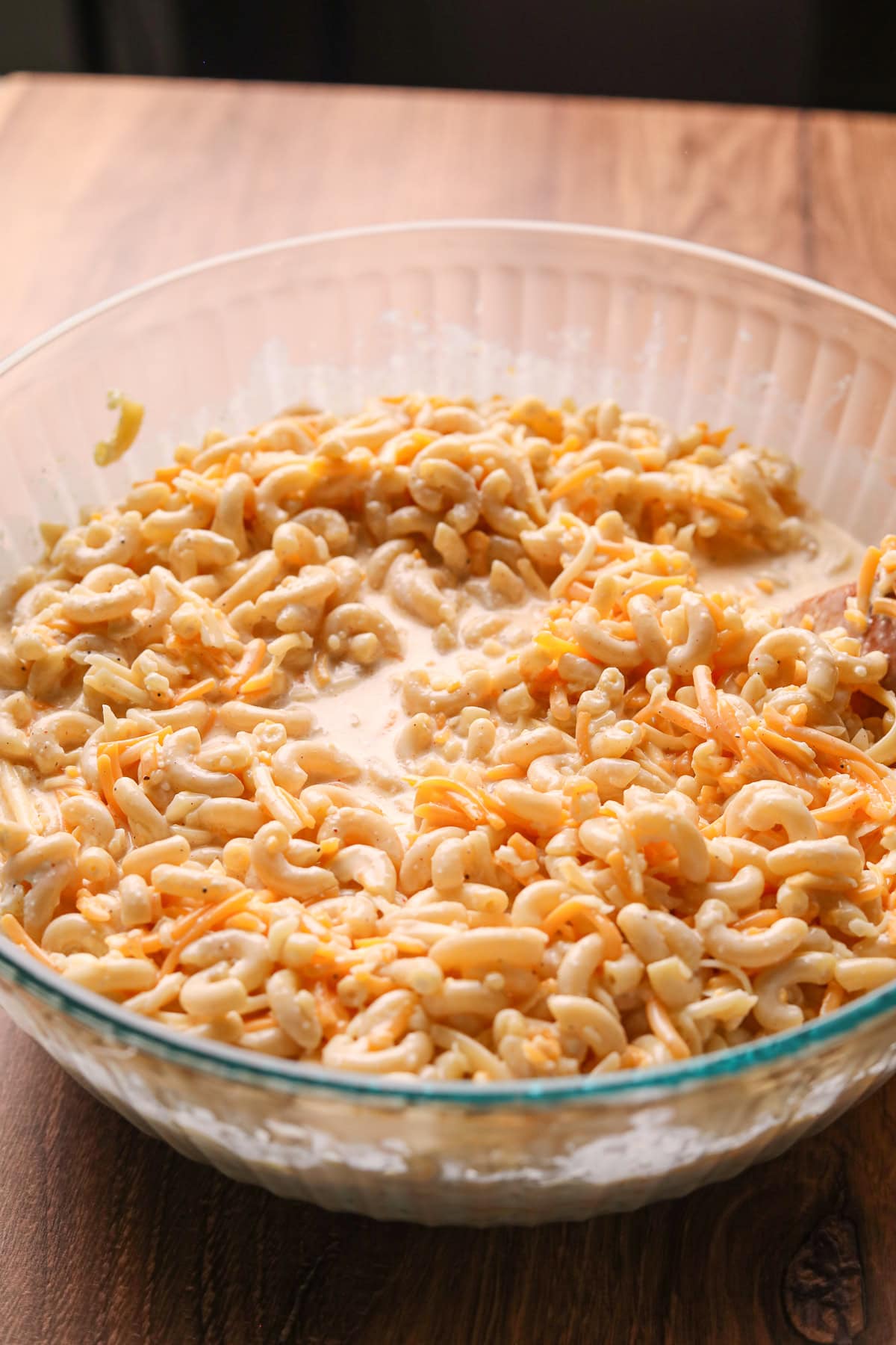 Creamy pasta and cheese mixture for southern baked mac & cheese in a large mixing bowl.