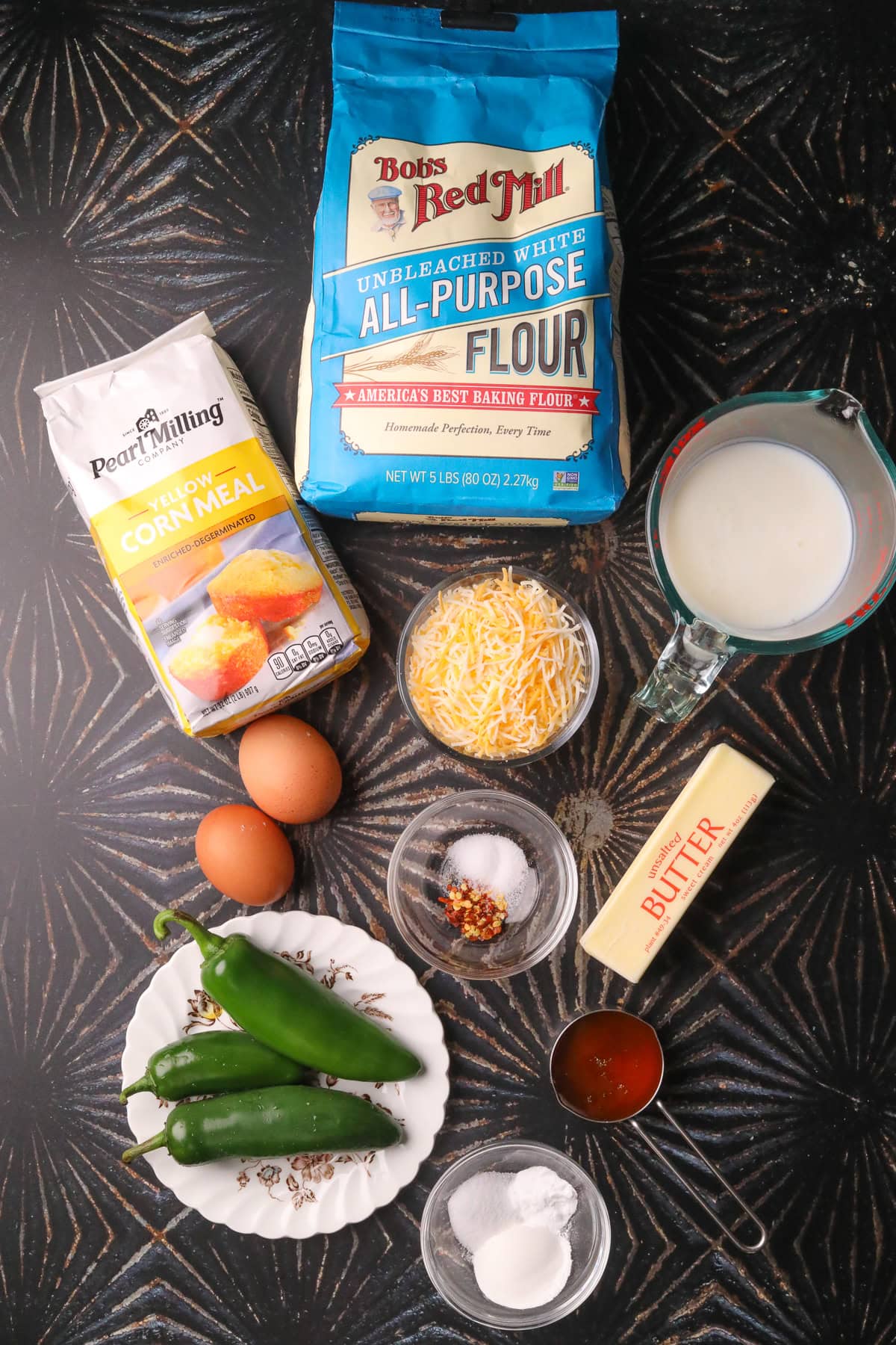 Jalapeño cheddar cornbread with spicy honey butter ingredients arranged on a table.