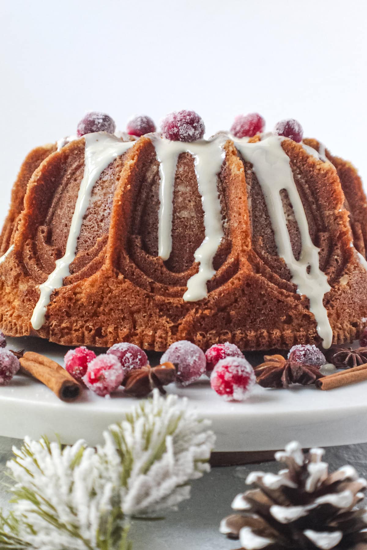 Spiced Bundt cake with maple cream cheese glaze on a cake plate.